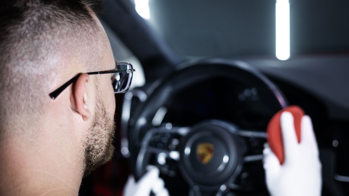 Detailarbeit am Lenkrad eines Porsche während der Innenraumaufbereitung