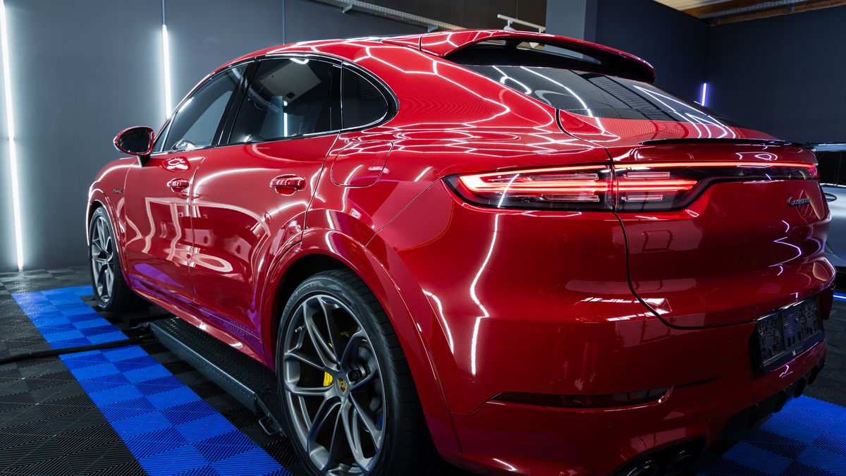 Lichtreflexionen im Lack eines roten Porsche Cayenne Coupé nach der Aufbereitung